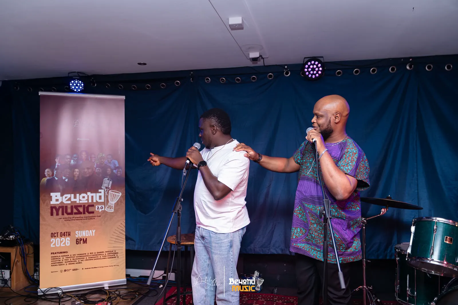 MC Crown in white sharing the stage with another performer at Beyond Music