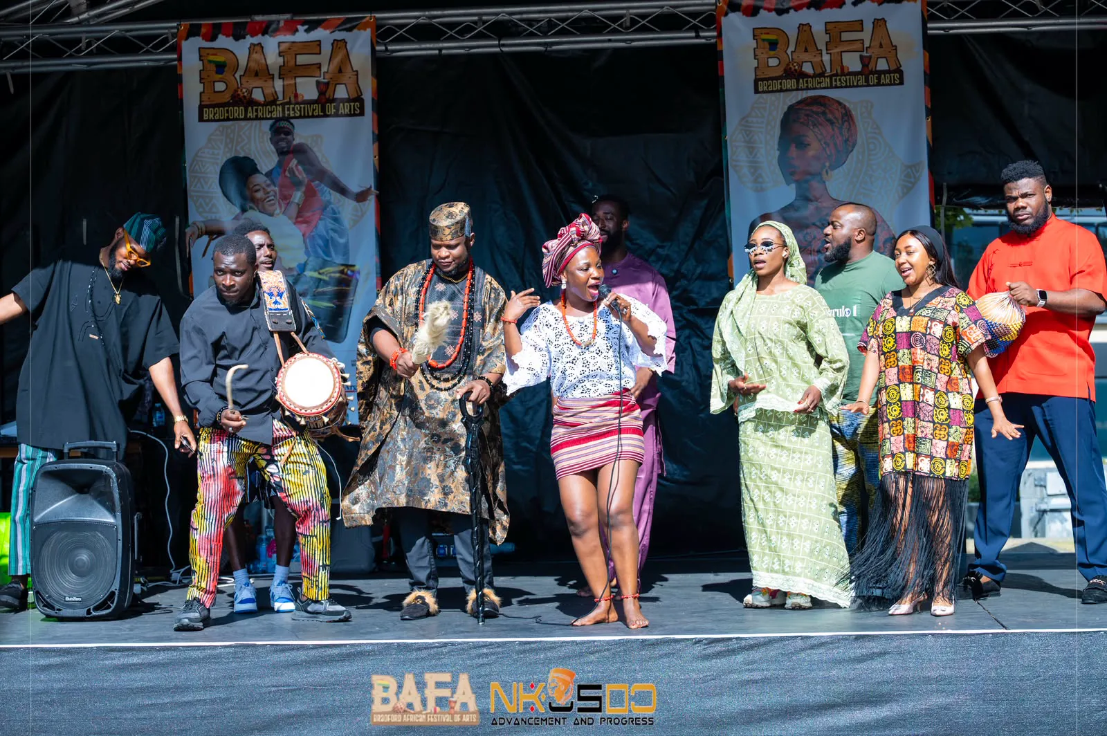 MC Crown with a talking drum among performers on the Bradford African Festival of Arts stage