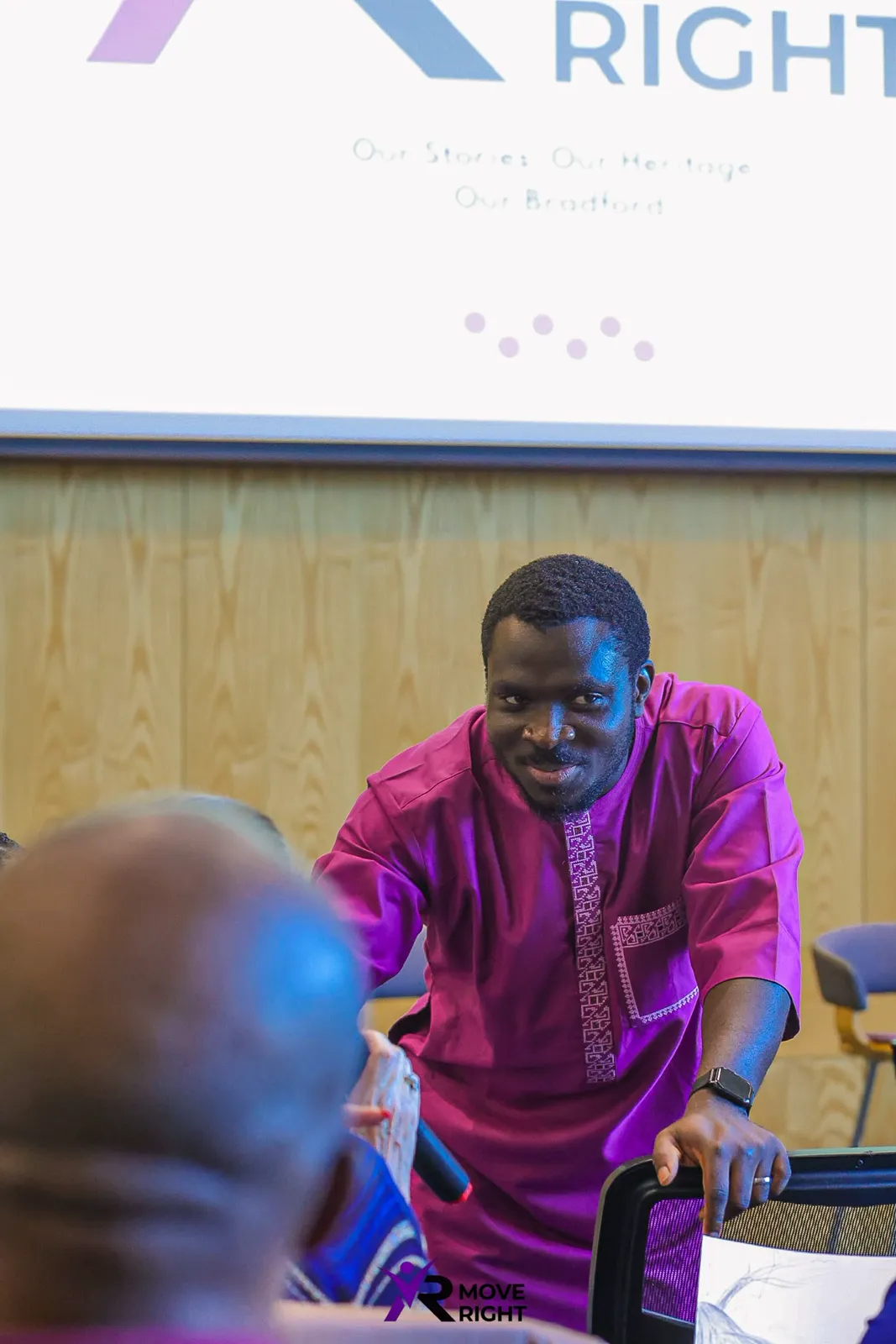MC Crown leaning towards audience members during a live performance